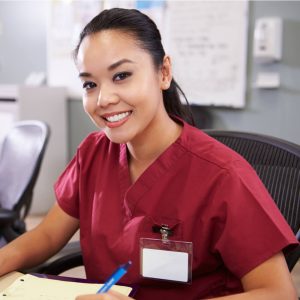 Portrait Of Female Nurse Working At Nurses Station